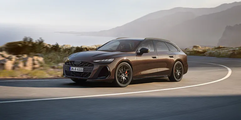 Ein dunkles Fahrzeug von Audi fährt auf einer Straße